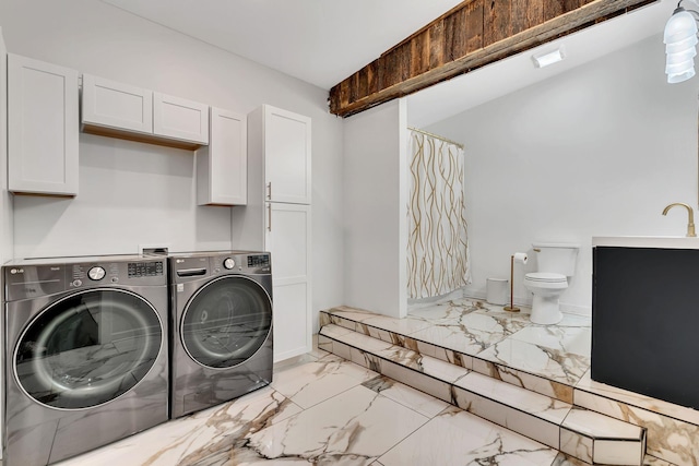 laundry room with separate washer and dryer and cabinets