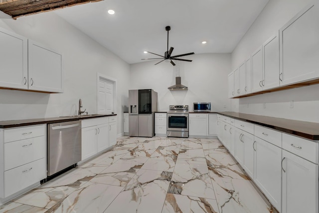 kitchen featuring sink, appliances with stainless steel finishes, wall chimney exhaust hood, and white cabinetry