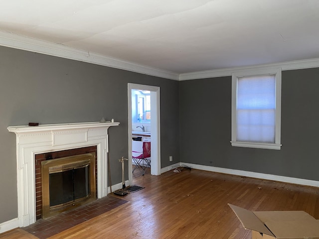 unfurnished living room featuring sink, a fireplace, ornamental molding, and dark hardwood / wood-style floors