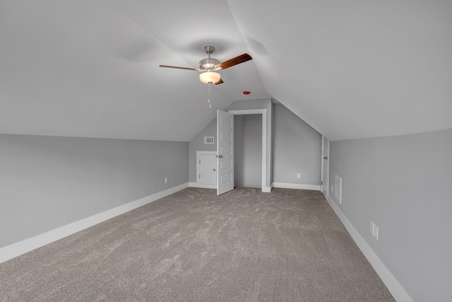 additional living space with ceiling fan, lofted ceiling, and light colored carpet