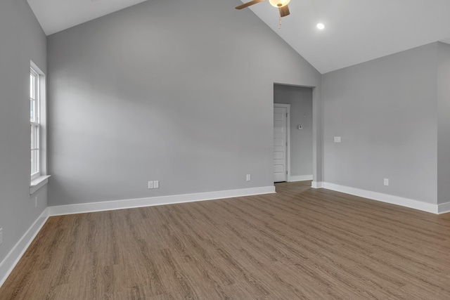 unfurnished room featuring ceiling fan, a healthy amount of sunlight, wood-type flooring, and high vaulted ceiling