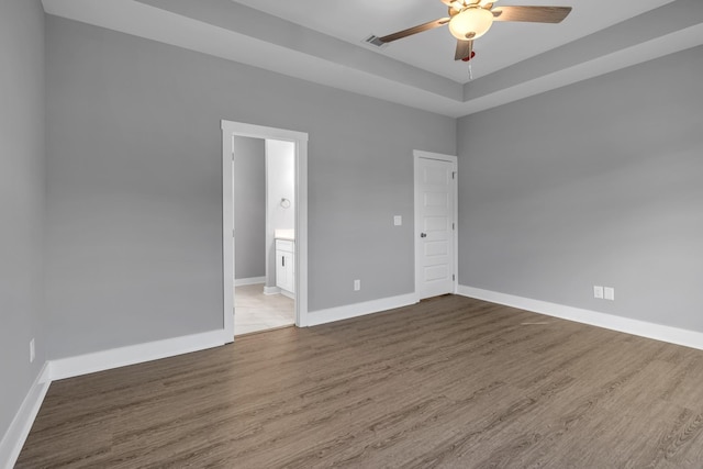 spare room featuring ceiling fan, hardwood / wood-style floors, and a tray ceiling