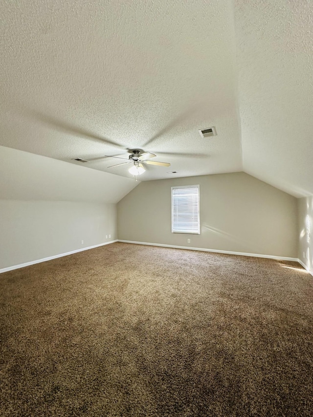 bonus room featuring lofted ceiling, a textured ceiling, and carpet