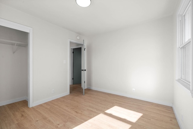 unfurnished bedroom featuring a closet and light wood-type flooring