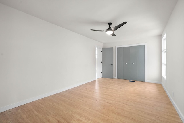 unfurnished bedroom featuring ceiling fan, light hardwood / wood-style floors, and a closet