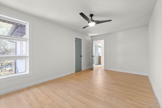 empty room featuring ceiling fan, a healthy amount of sunlight, and light hardwood / wood-style flooring