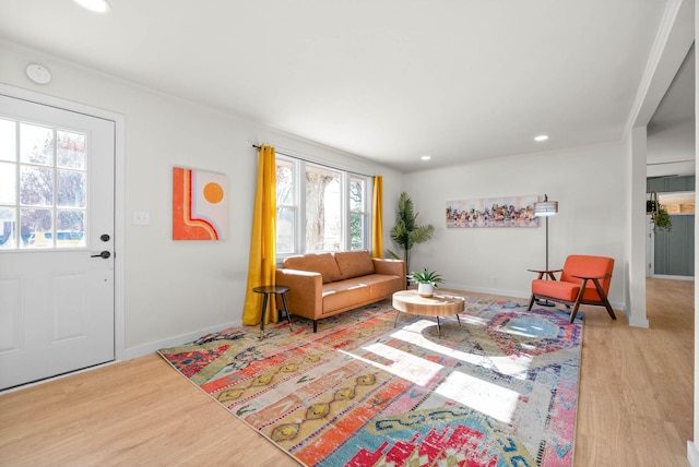 living room with ornamental molding and light hardwood / wood-style floors