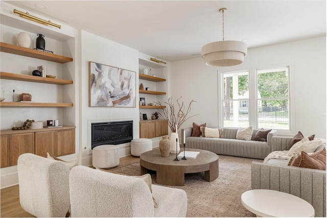 living room with light wood-type flooring and built in shelves