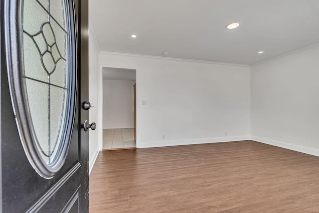 foyer entrance featuring crown molding and hardwood / wood-style flooring