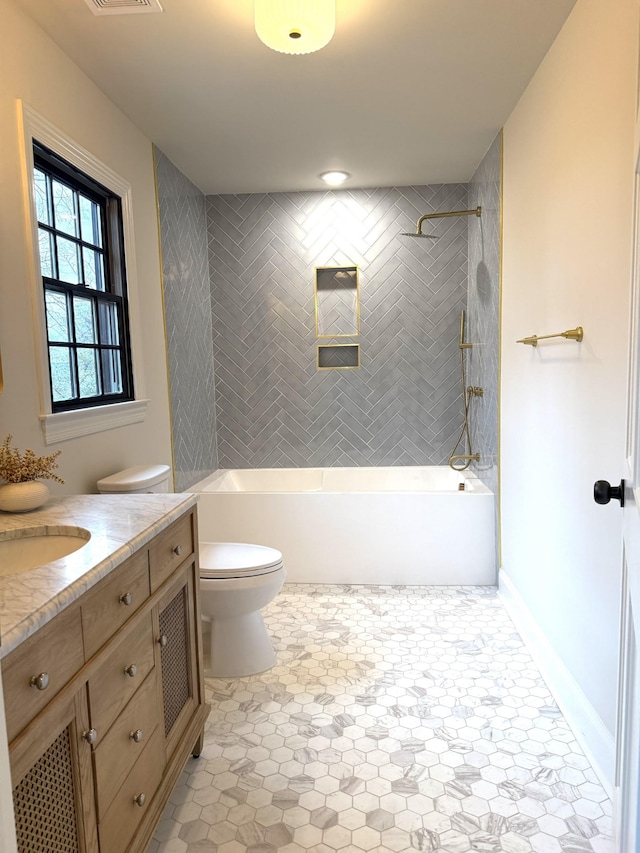 full bathroom with vanity, toilet, and tiled shower / bath combo