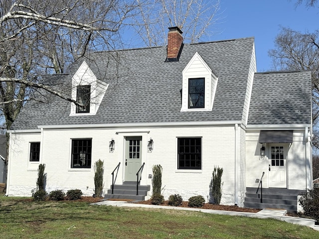 cape cod house with a front lawn