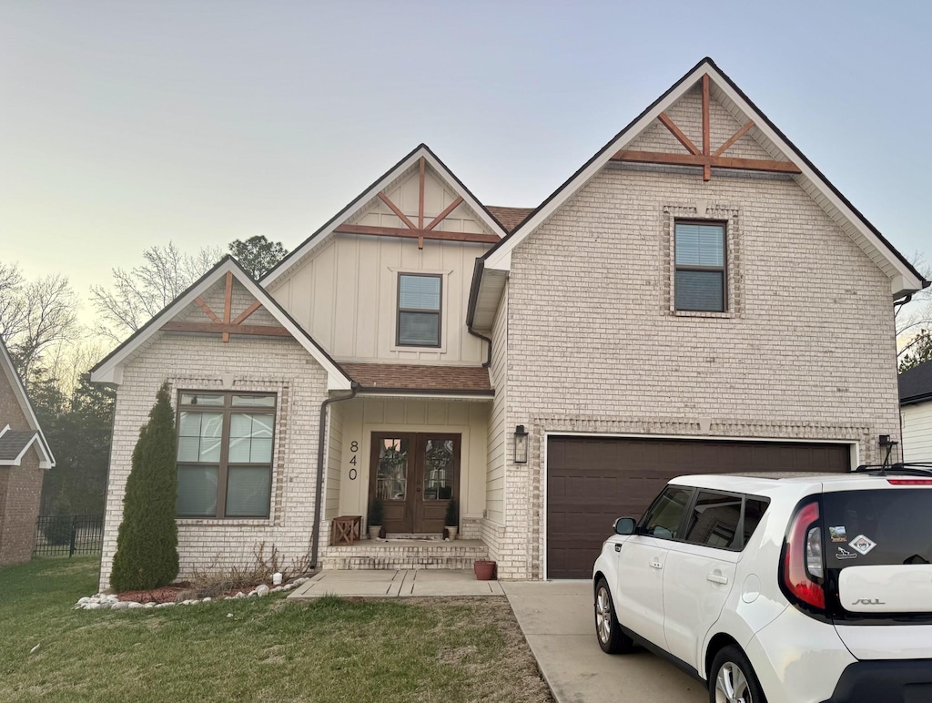 view of front facade with french doors, a front lawn, and a garage