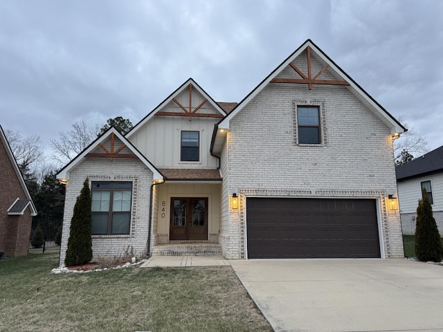 view of front of home featuring french doors, a garage, and a front lawn