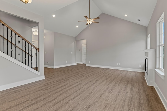 unfurnished living room featuring ceiling fan, high vaulted ceiling, and wood-type flooring