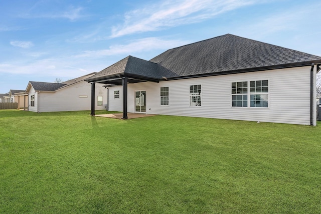 rear view of house with a lawn and a patio