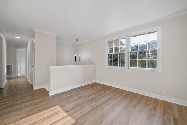 unfurnished room featuring ornamental molding and light wood-type flooring