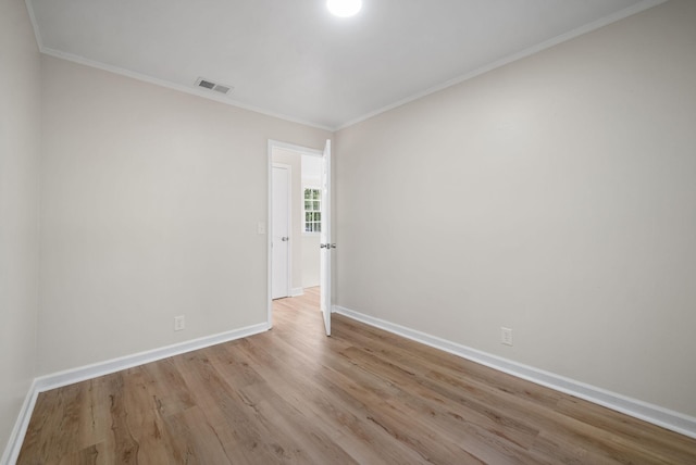 unfurnished room featuring ornamental molding and light hardwood / wood-style floors