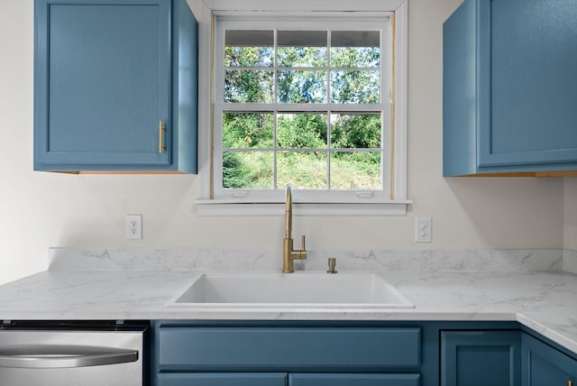 kitchen with sink, stainless steel dishwasher, and blue cabinetry