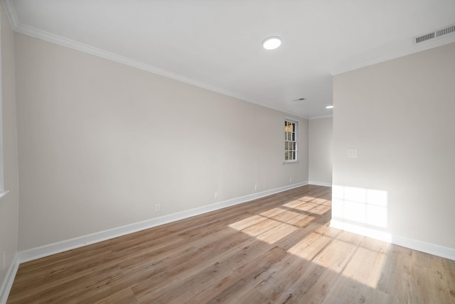 empty room with light wood-type flooring and crown molding