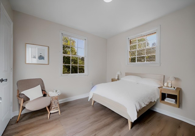 bedroom with baseboards and light wood finished floors