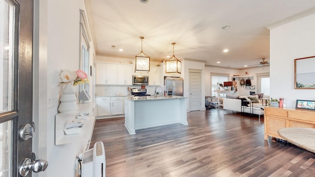 kitchen with hanging light fixtures, a center island with sink, white cabinetry, appliances with stainless steel finishes, and ceiling fan