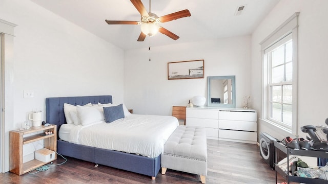 bedroom with ceiling fan, dark wood-type flooring, and multiple windows