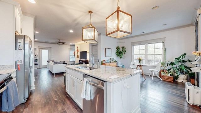 kitchen with appliances with stainless steel finishes, hanging light fixtures, white cabinets, and sink