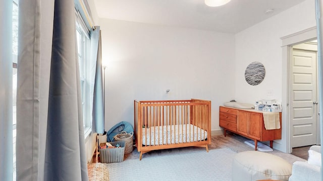 carpeted bedroom featuring a crib