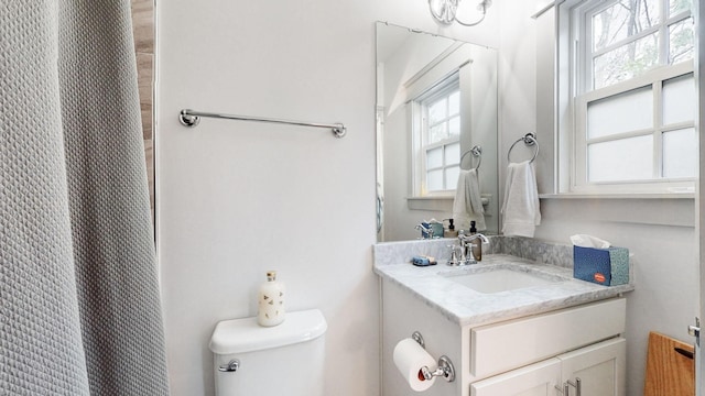 bathroom with a wealth of natural light, vanity, and toilet