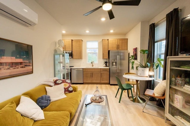 kitchen with sink, light hardwood / wood-style floors, decorative backsplash, a wall mounted air conditioner, and appliances with stainless steel finishes