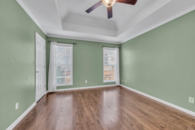 unfurnished room with a raised ceiling, ceiling fan, crown molding, and hardwood / wood-style floors