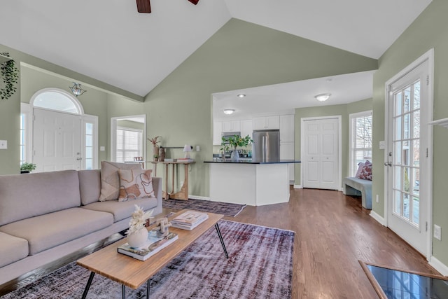 living room featuring a healthy amount of sunlight, ceiling fan, high vaulted ceiling, and dark hardwood / wood-style floors