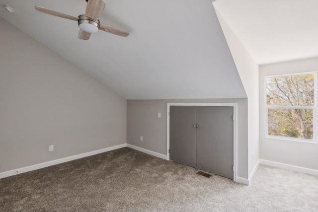 additional living space featuring lofted ceiling, light carpet, and ceiling fan