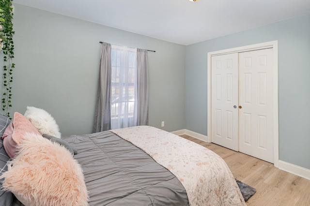 bedroom with light wood-type flooring and a closet