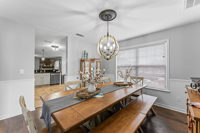 dining area featuring sink, a chandelier, and light hardwood / wood-style floors