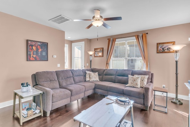 living room featuring ceiling fan and dark hardwood / wood-style flooring