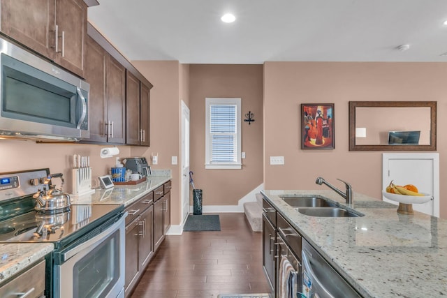 kitchen with appliances with stainless steel finishes, light stone countertops, and sink