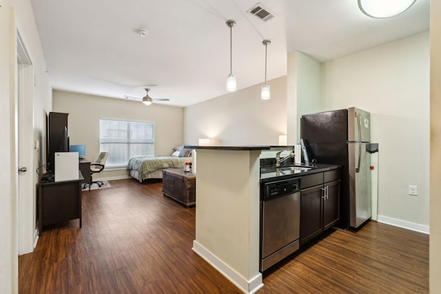 kitchen featuring dark wood-style floors, dark countertops, visible vents, appliances with stainless steel finishes, and a sink