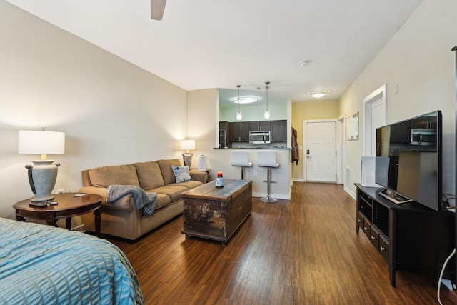 living area featuring dark wood-style flooring and baseboards