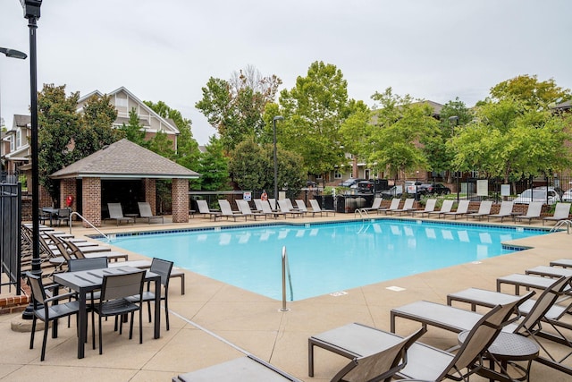 community pool with fence and a patio