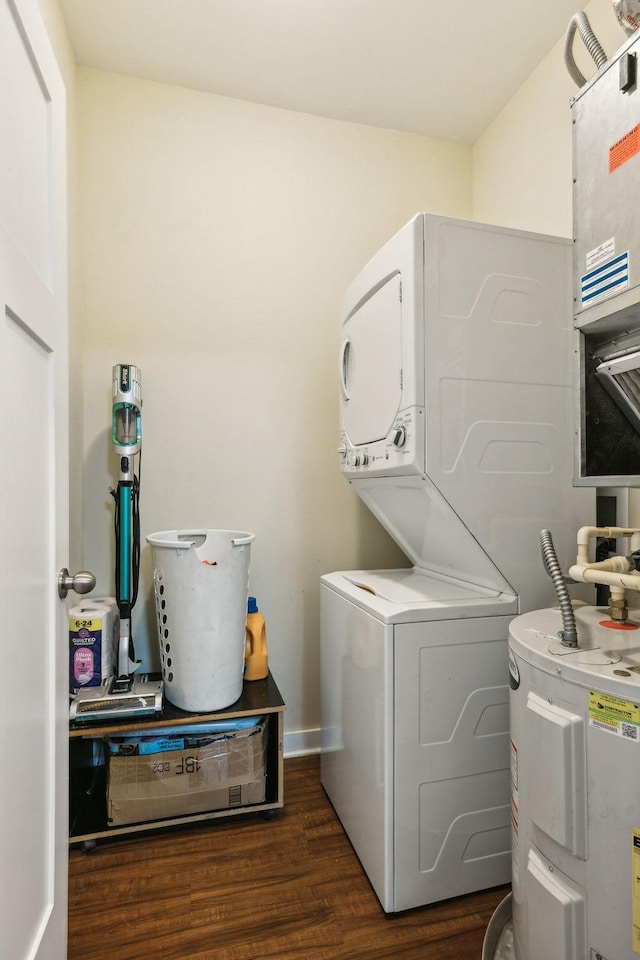 washroom featuring laundry area, baseboards, water heater, stacked washing maching and dryer, and dark wood-style floors