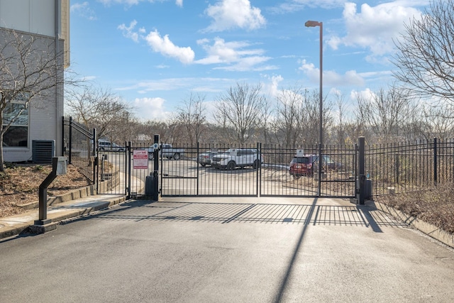 view of gate featuring cooling unit and fence