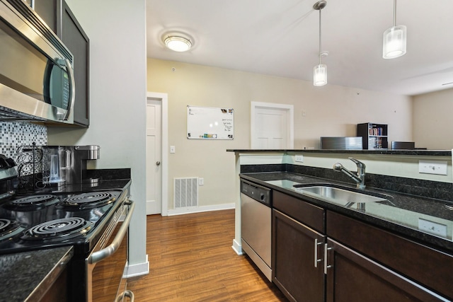 kitchen featuring dark wood-style flooring, a sink, visible vents, dark brown cabinets, and appliances with stainless steel finishes