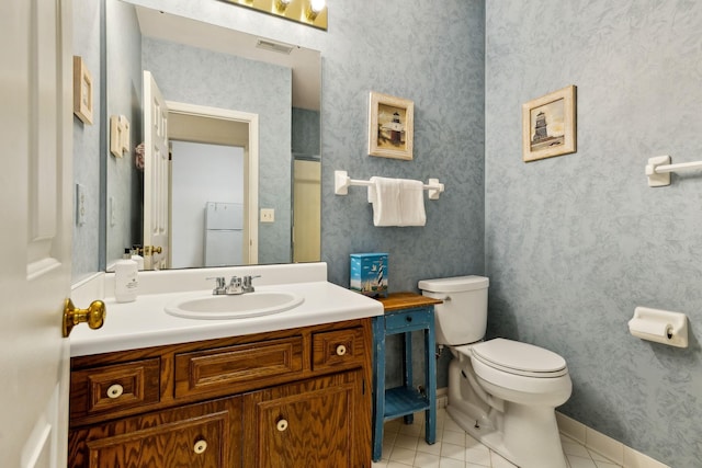 bathroom with tile patterned flooring, vanity, and toilet