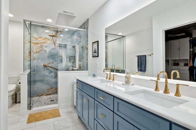 bathroom featuring vanity, a shower with shower door, and toilet