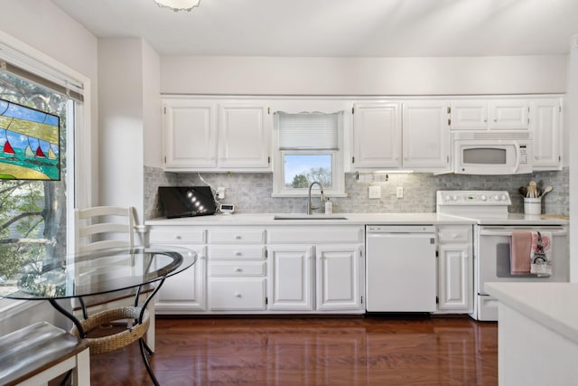 kitchen with sink, backsplash, dark hardwood / wood-style flooring, white cabinets, and white appliances