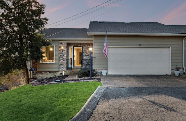 view of front of house featuring a yard and a garage