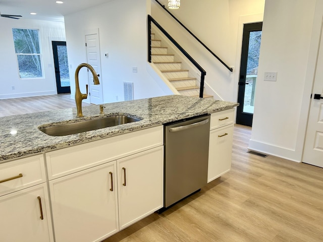 kitchen featuring sink, white cabinets, dishwasher, and light stone countertops