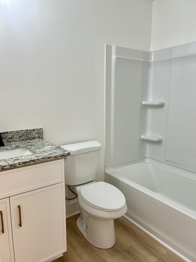 full bathroom with shower / tub combination, toilet, vanity, and hardwood / wood-style flooring