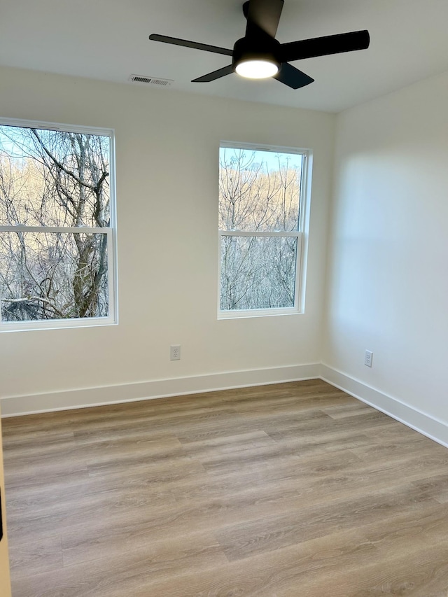 unfurnished room with light hardwood / wood-style floors, ceiling fan, and a wealth of natural light